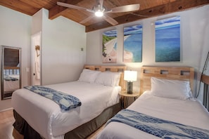 A hotel room with two beds, a ceiling fan, and artwork depicting beach scenes. - The Ultimate Escape. Relax, Enjoy, Steps to Beach (Kihei)