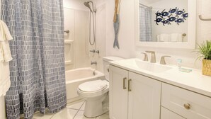 A bathroom with a shower, toilet, and sink.