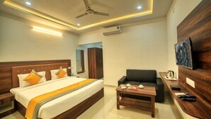 A hotel room with a bed, a sofa, a desk, and a ceiling fan. - Visa Inn Bangalore Airport (Bengaluru)