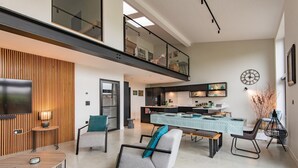 Een moderne woonkamer met een bank, salontafel en een eethoek met een tafel en stoelen.