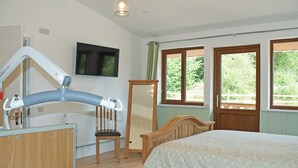 A bedroom with a bed, a chair, a desk, a television, and a window. - 3 bedroom accommodation in Llandrindod Wells (Llandrindod Wells)