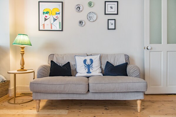 A living room with a grey sofa, a lamp, and wall art. - Star Cottage, Whitstable (Whitstable)