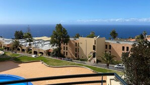 Vista di una zona costiera con edifici, una piscina e una spiaggia libera, con l'oceano in vista.