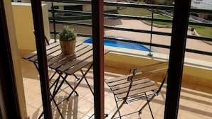 Un balcone con piscina, un tavolo e una sedia.