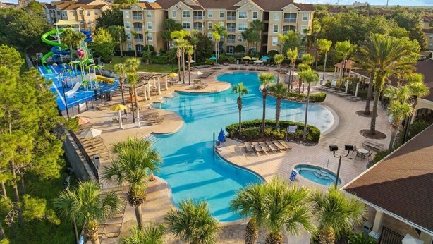 A resort with multiple swimming pools, a water park, and a building with balconies. - Wizarding Retreat: Enchanted Harry Potter Condo (Kissimmee)