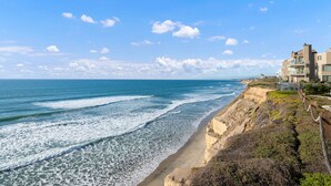 A coastal hotel with a beach view, a rocky cliff, and a clear sky. - Oceanfront - Ocean Views - Pool  Spa - Pickleball - Walk To All - Renovated (Solana Beach)