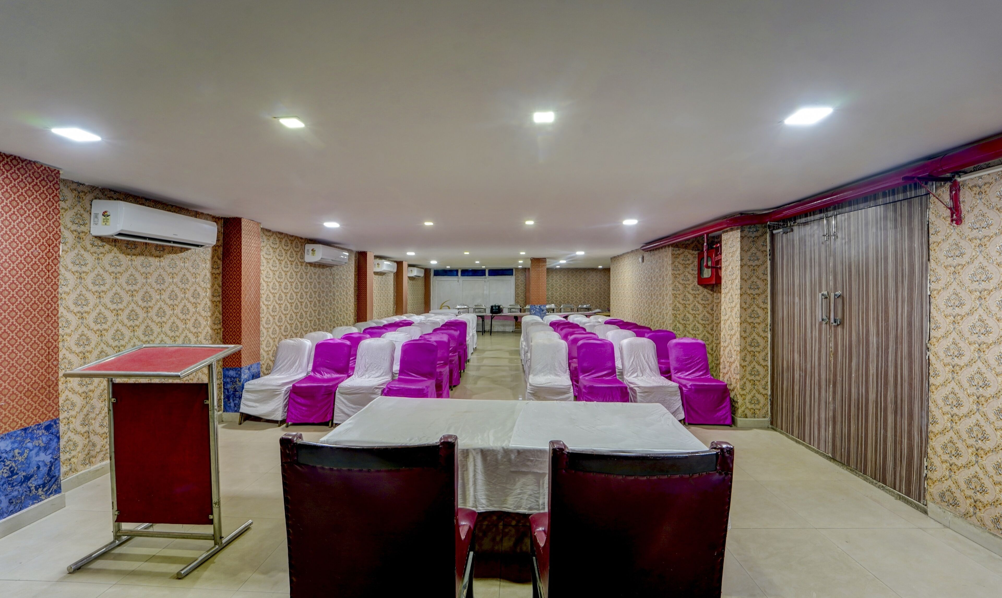 A conference room with rows of chairs, a podium, and a stage.