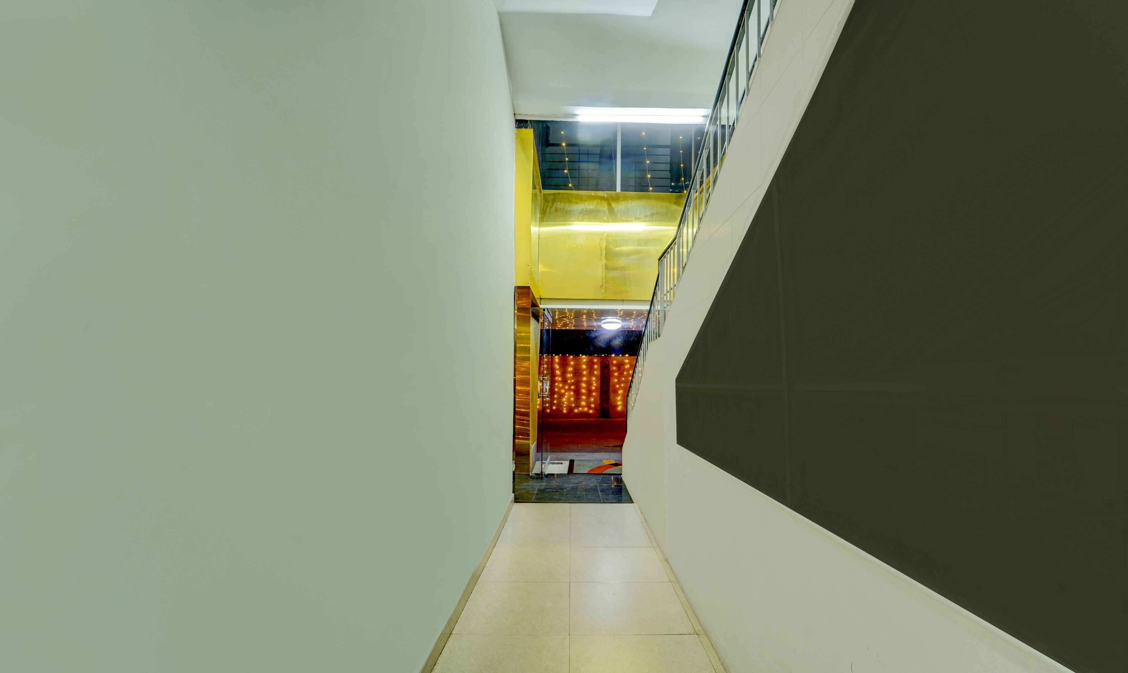 A corridor with a staircase leading to a lower level.