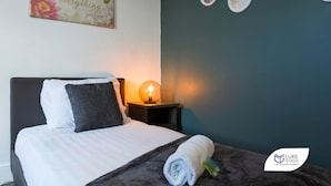 A hotel room with a bed, a bedside lamp, a wall with three round mirrors, and a motivational quote on the wall. - Luke Stays - Rokeby Street (Newcastle Upon Tyne)