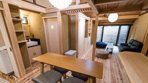 Un intérieur en bois, de taille réduite, comprenant un coin repas, un canapé et une petite cuisine.