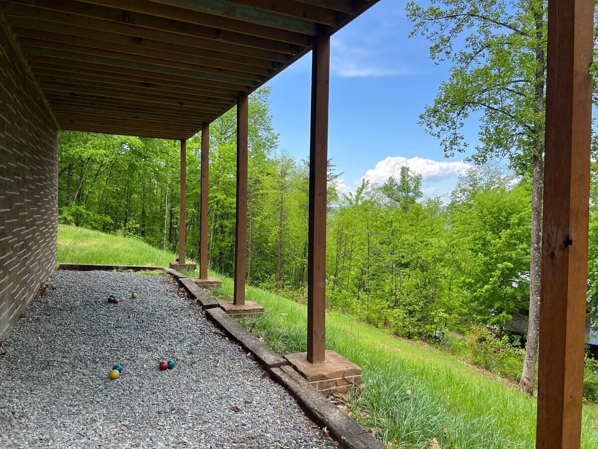 Un espace extérieur abrité, doté d’un chemin de gravier, de poteaux en bois et d’un mur en briques.