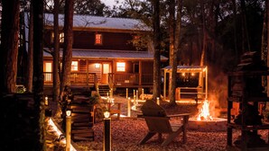 Un chalet rustique doté d’une véranda, d’un foyer et d’une terrasse en bois.