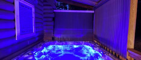 Un jacuzzi en una cabaña de madera con un letrero que dice "The Porch" y un cartel con texto.
