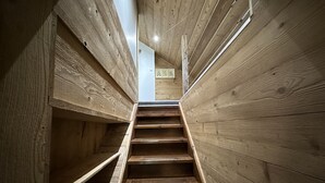 Een houten trap in een gebouw met een hoge plafond en houten wanden.