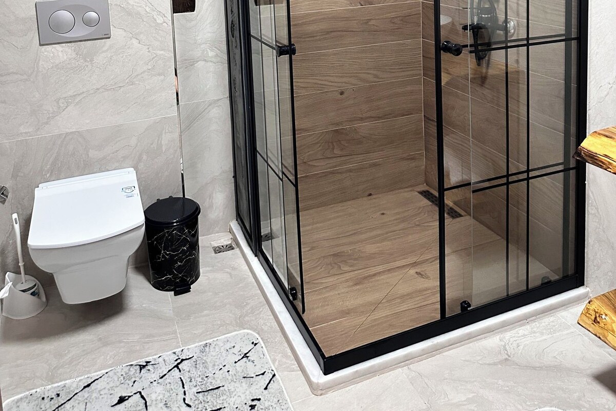 Une salle de bain moderne avec une douche à parois de verre, des toilettes et un bidet.