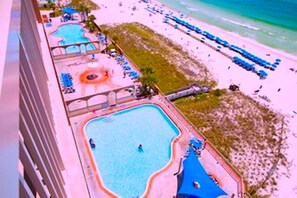 A resort with multiple swimming pools, a beach area, and lounge chairs. - Beautifully furnished with recliners. Close to Pier Park and Frank Brown Park. (Panama City)