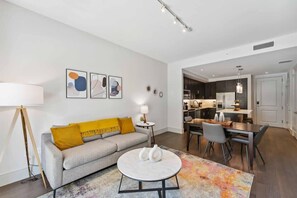 Uma sala de estar moderna com sofá, mesa de centro e uma obra de arte na parede.