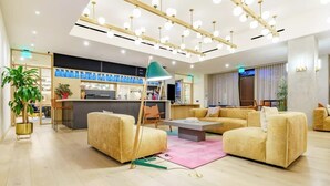 Een moderne hotel lobby met een receptiebalie, banken en een salontafel.
