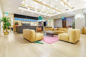 Un hall d’hôtel moderne avec un comptoir d’accueil, des canapés et une table basse.