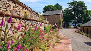 A stone building with a gravel path leading to a wooden door.