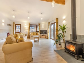 Una sala de estar acogedora con un sofá, una mesa de centro, una chimenea y un televisor.