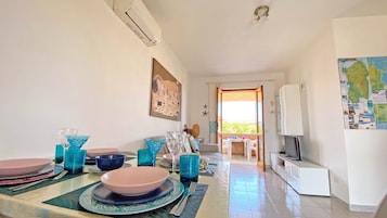 Zona pranzo con tavolo apparecchiato per quattro, una mappa appesa al muro e vista all'esterno.