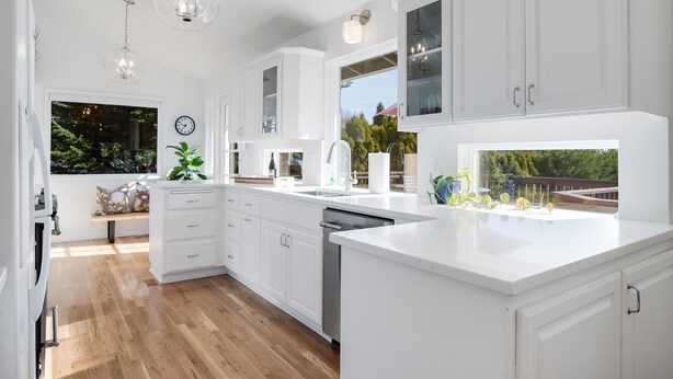 A modern kitchen with white cabinetry, a large island, and pendant lighting. - Alder House: A Single Level Home in Dundee Hills (Dundee)