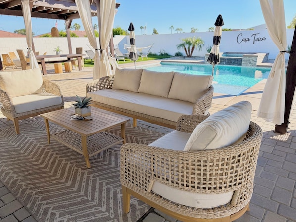 A patio area with wicker furniture, a pool, and a sign reading "Casa Terra".