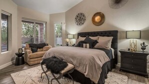 A bedroom with a large bed, a sofa, a chair, and a nightstand. - The Blotto | A Lush Desert Oasis (Phoenix)