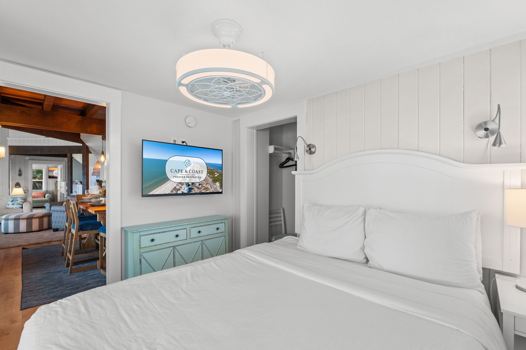 Una habitación de hotel con una cama, un televisor que muestra una vista panorámica, una lámpara de techo y una lámpara de pared.