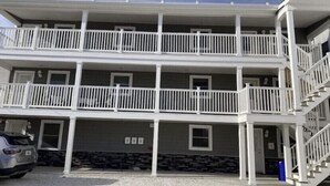 A multi-story building with balconies and a staircase.