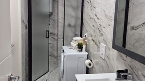 A modern bathroom with a glass shower enclosure, a built-in washing machine, and a large mirror. - Villa Ana Apartments - One Bedroom Apartment with Terrace and Sea View (Mlini)