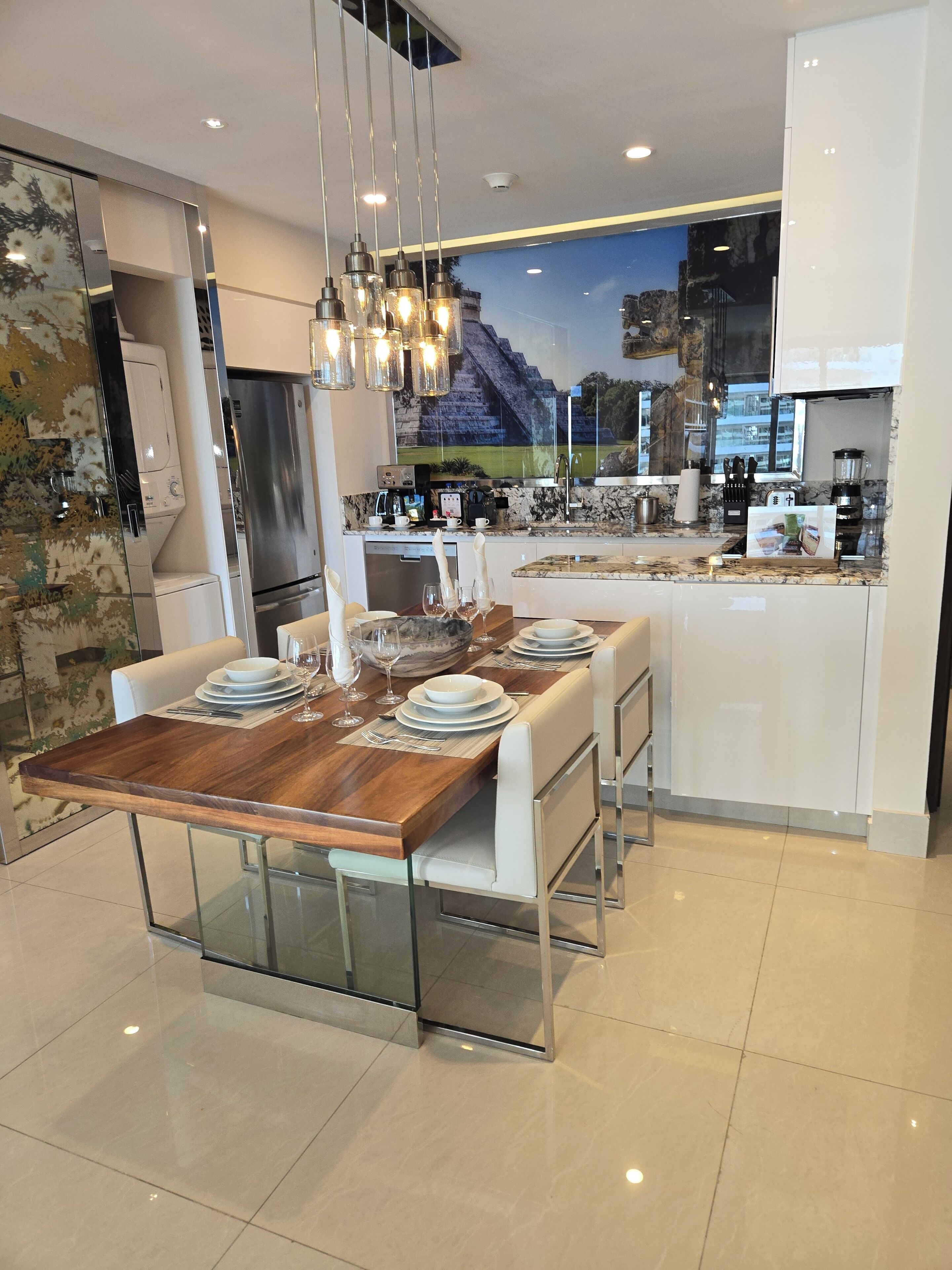 A modern kitchen with a central island, stainless steel appliances, and a large window with a cityscape view.