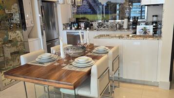 A modern kitchen with a central island, stainless steel appliances, and a large window with a cityscape view.
