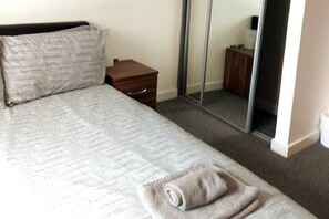 2 habitaciones, escritorio y tabla de planchar con plancha