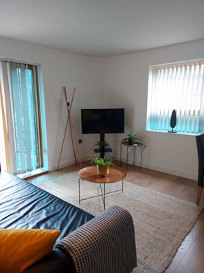 Relax in this serene space with a large bed, round coffee table, and a TV for entertainment.