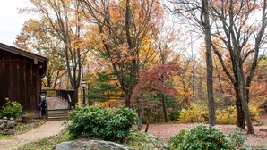 A rustic wooden cabin with a wooden deck and a stone pathway leading to it. - Mountain cabin by Shenandoah National Park (Stanardsville)