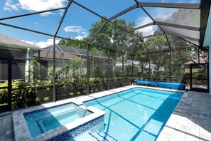 Une piscine extérieure couverte offrant une vue sur les arbres environnants et une maison.