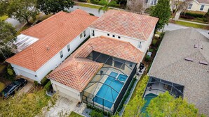 Ein Wohnhaus mit Swimmingpool, Garage und Auffahrt.
