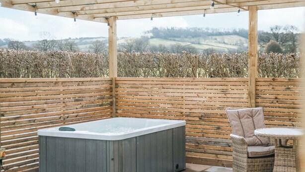 A wooden pergola with a hot tub and wicker chairs. - Swallow Lodge - UK42540 (Clifford)