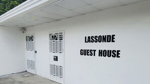 Valkoinen rakennus, jossa on kaksi ovea ja kyltti, jossa lukee: ”LASSONDE GUEST HOUSE”.