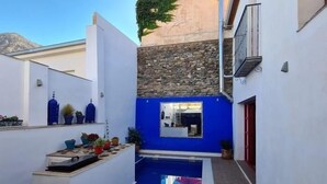 A narrow courtyard with a blue-tiled pool, white walls, and a stone wall. - Fantastic rural house in Nigüelas (Nigüelas)