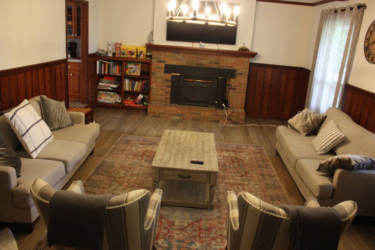 Una sala de estar acogedora con chimenea, una estantería y dos sofás.