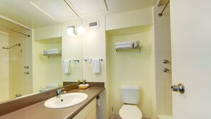 Un baño con lavamanos, inodoro y ducha.
