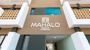 A building with a prominent 'MAHALO' sign and a modern architectural design.