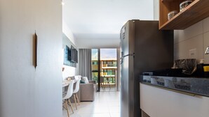 A modern kitchen with a built-in refrigerator, a dining area with a table and chairs, and a view of the outside balcony.