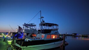 A docked boat with a cabin, a flag, and a helipad. - Paradise on the Great South Bay (Cherry Grove)