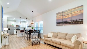 A modern living room with a beige sofa, a patterned armchair, and a dining area with a table and chairs. - 1 Mi to Beach: Retreat w/ Large Yard in Rockport (Rockport)