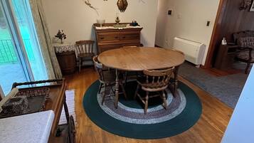 A dining room with a round wooden table surrounded by chairs, a ceiling fan, and decorative wall art.