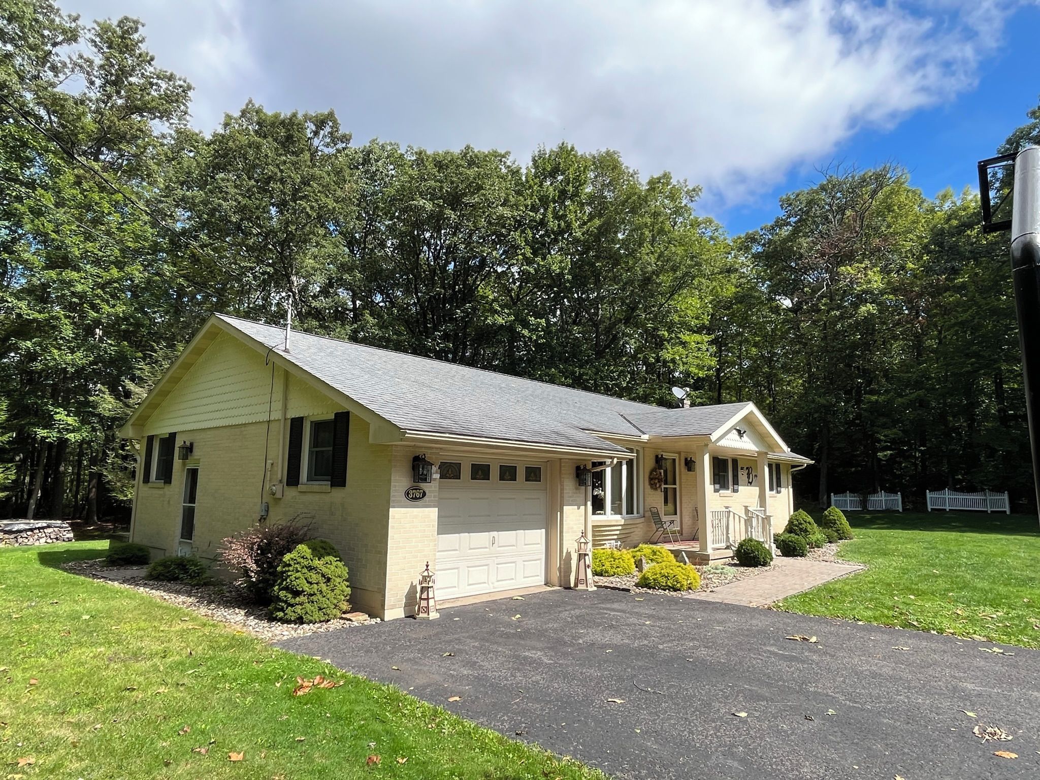 A single-story house with a garage, a front porch, and a driveway.